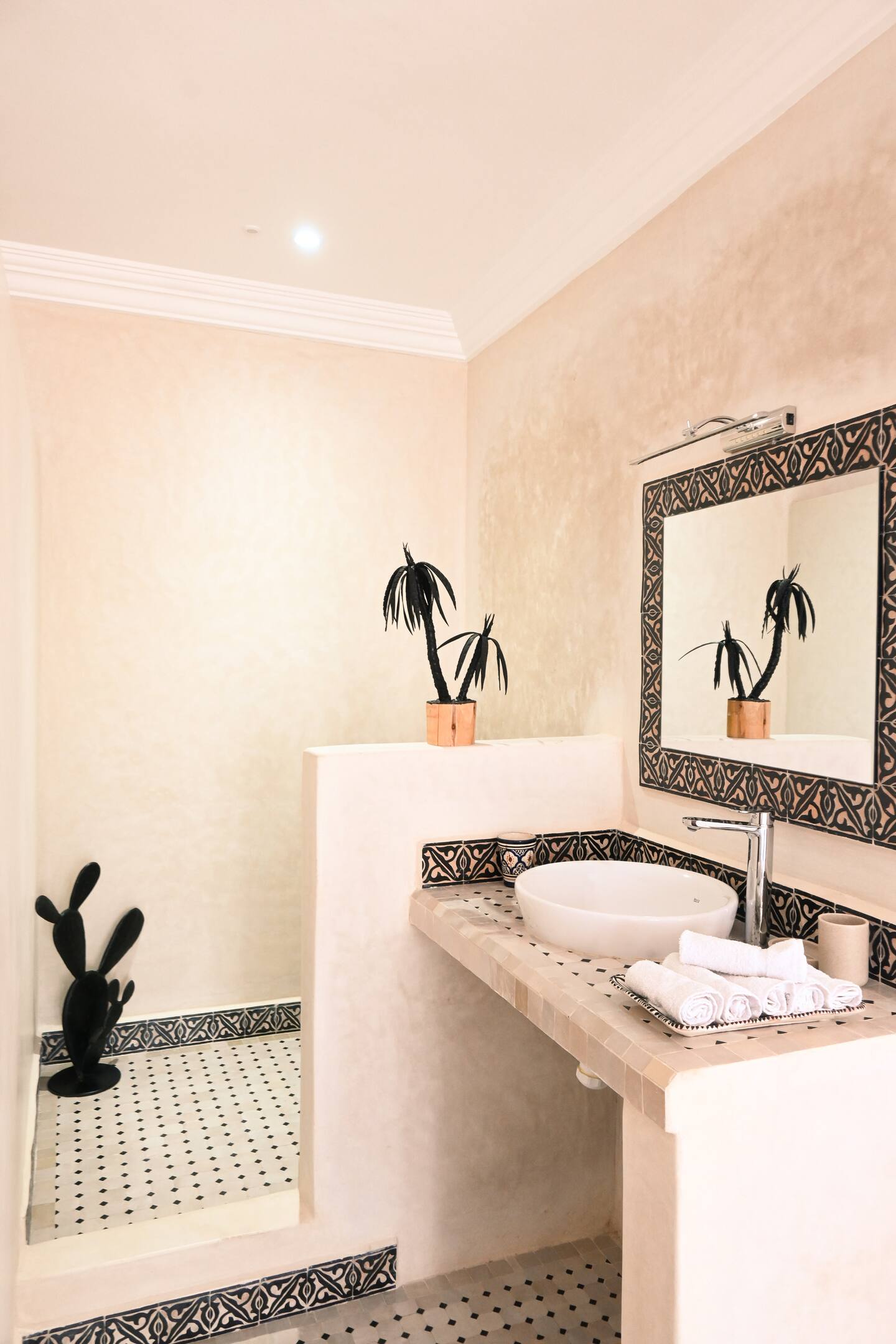 Salle de bain de la suite Itri à Berber Shelter, Tamraght près de Taghazout, avec vasque en zellige, grand miroir et décoration marocaine artisanale.