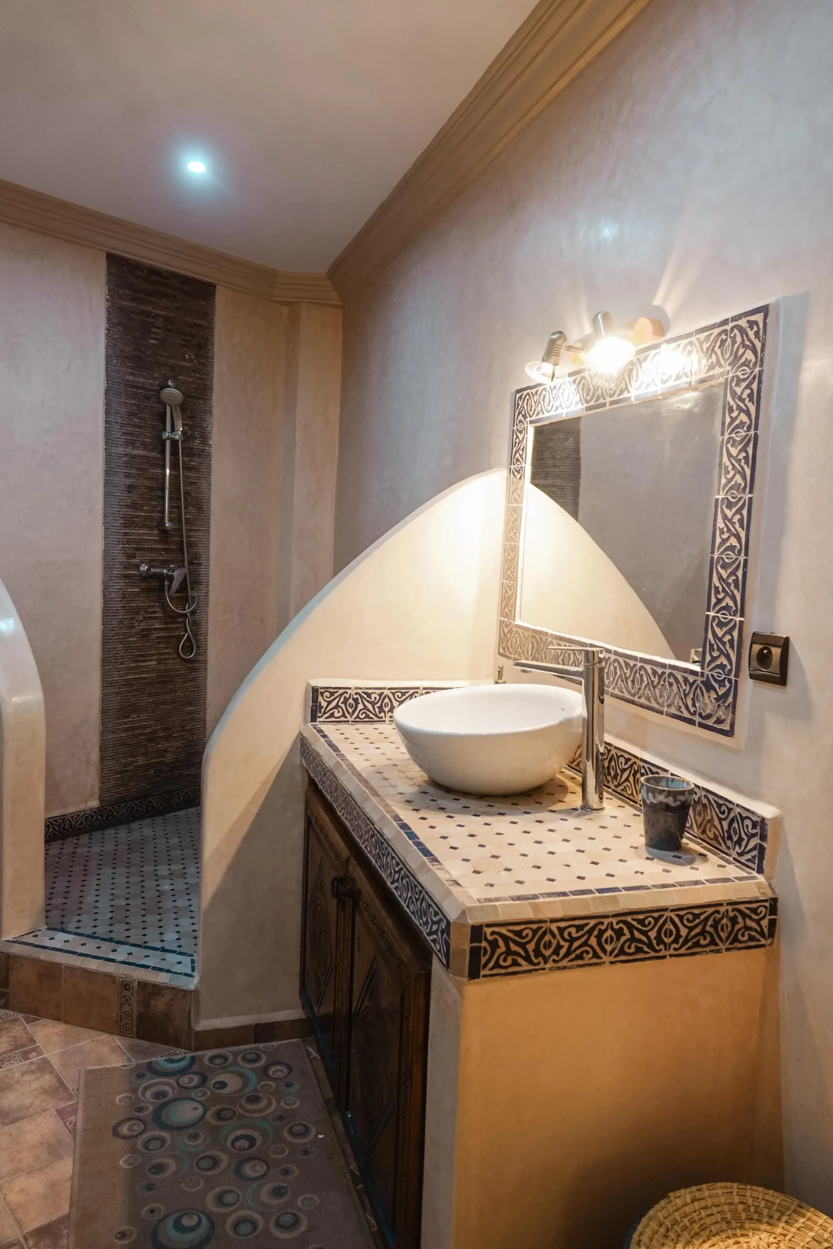 Salle de bain de l’appartement Ayour à Berber Shelter, décorée de zelliges et dotée d’une douche à l’italienne à Tamraght.