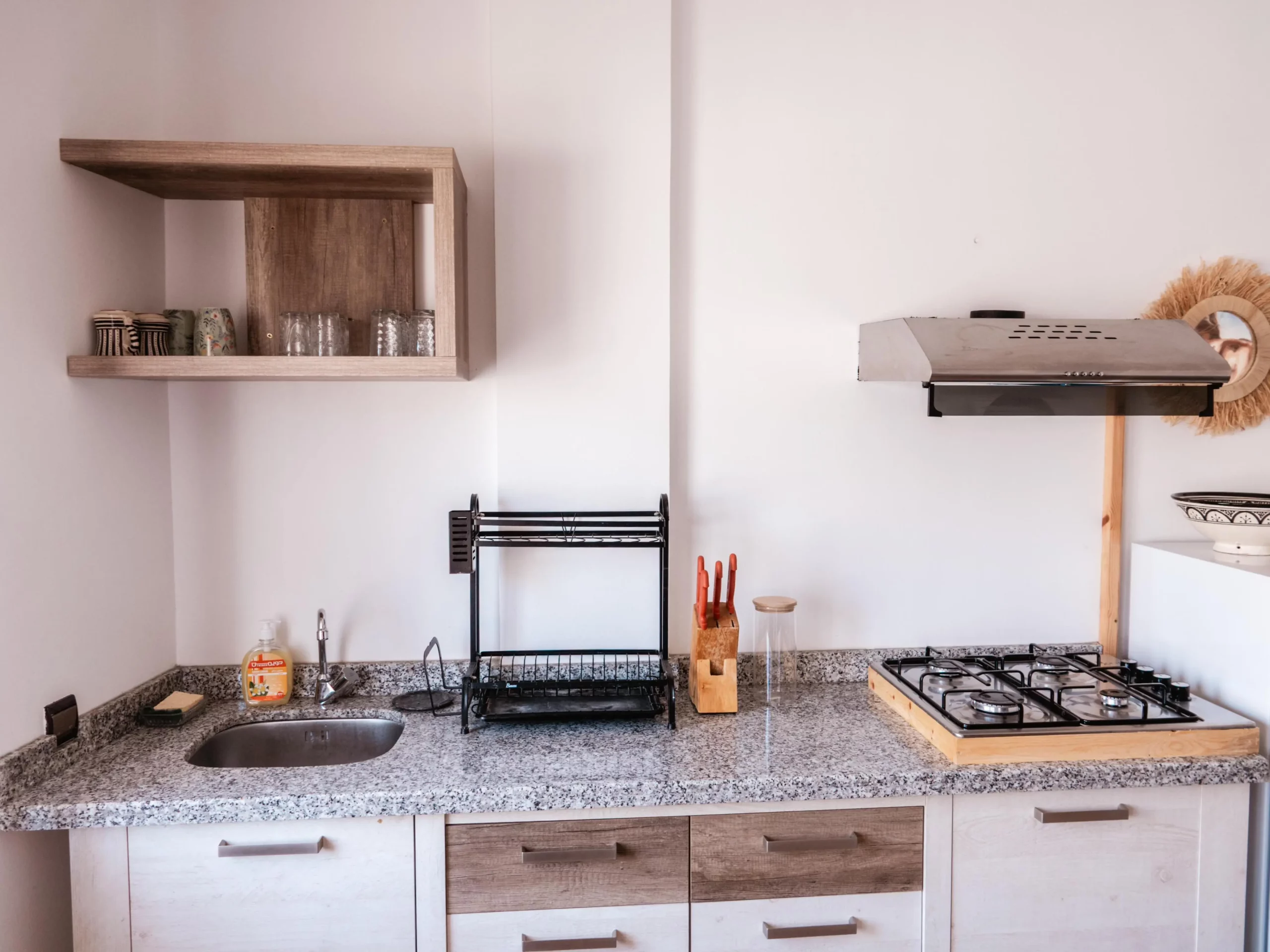 Cuisine équipée de l’appartement Ayour à Berber Shelter, avec plaques de cuisson, micro-ondes, frigo et bouilloire à Tamraght.