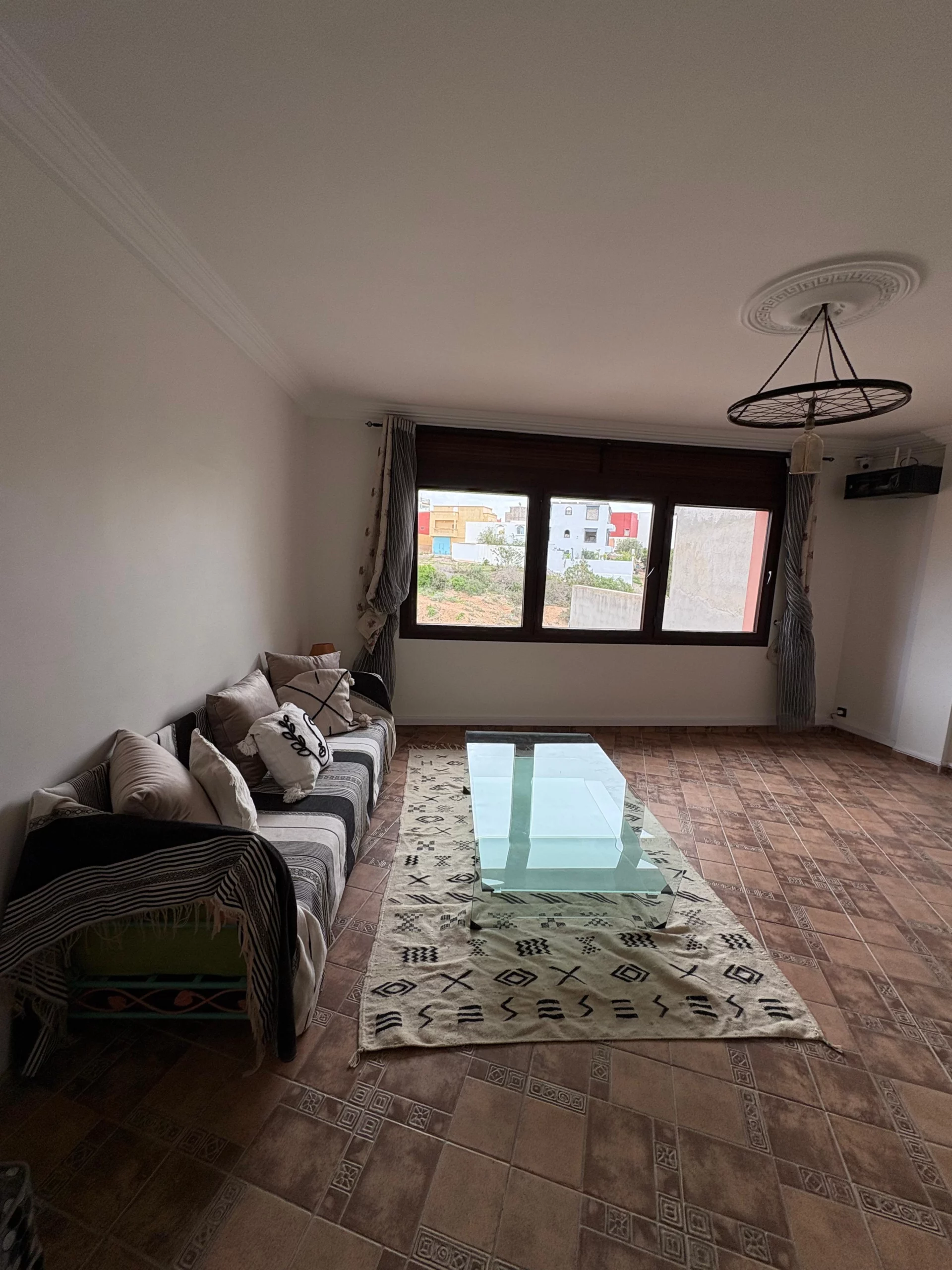 Grand salon lumineux de la suite Itri à Berber Shelter, maison d’hôtes à Tamraght près de Taghazout, avec vue sur le village et décoration marocaine moderne.