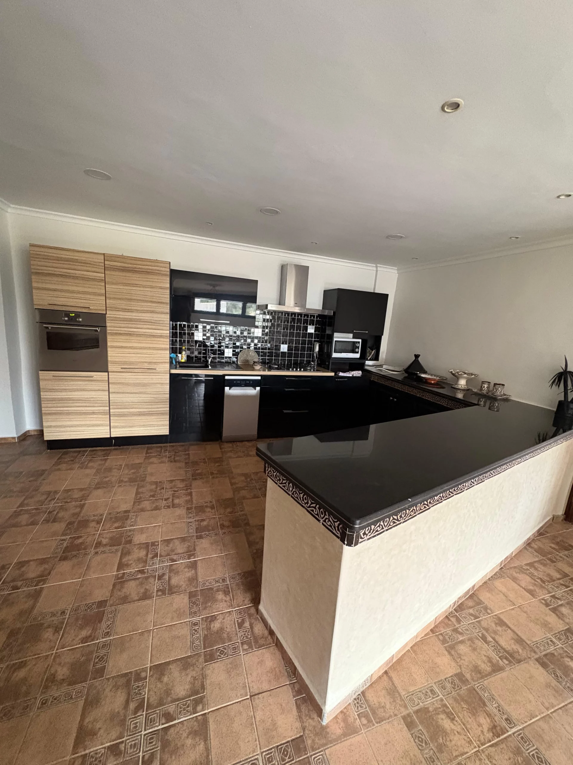 Cuisine à l’américaine toute équipée de la suite Itri à Berber Shelter, Tamraght près de Taghazout, avec plaques, réfrigérateur, micro-ondes et bouilloire.